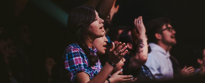 Des personnes qui chantent et applaudissent à un concert